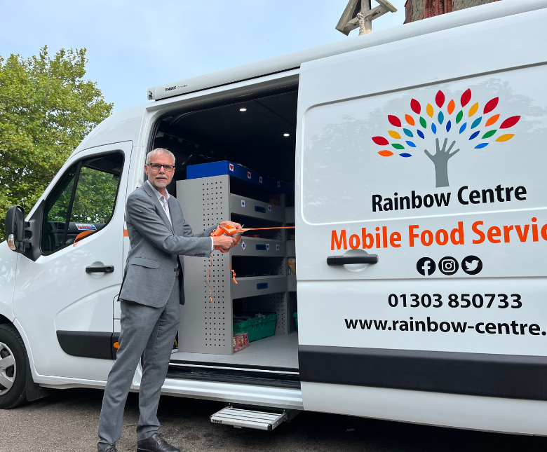 Folkestone and Hythe district councillor Mike Blakemore cuts an orange ribbon at the door of the mobile food van to officially launch the service.