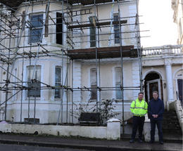 An image of two people in front of one of the buildings benefiting from the No Use Empty scheme